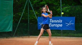 Giovane tennista in azione su campo in terra rossa, concentrazione e passione.