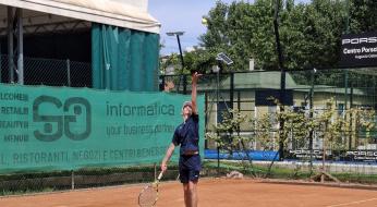 Giocatore di tennis serve su campo in terra, sotto un cielo sereno.
