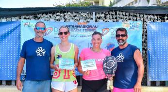 Quattro persone sorridenti festeggiano un secondo posto in un torneo di beach tennis.