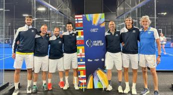 Squadra di padel in posa, sorrisi entusiasti, bandiere colorate sullo sfondo.